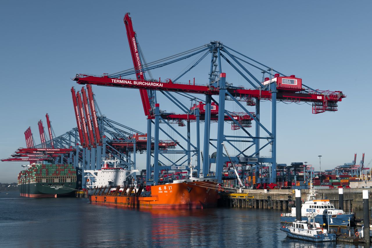 our-services-1 Container ships docked at Hamburg's busy Terminal Burchardkai under cranes.